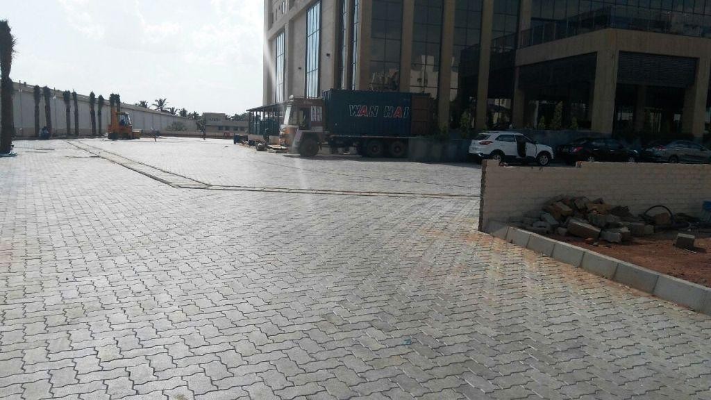 Paved outdoor area beside a commercial building with glass facade